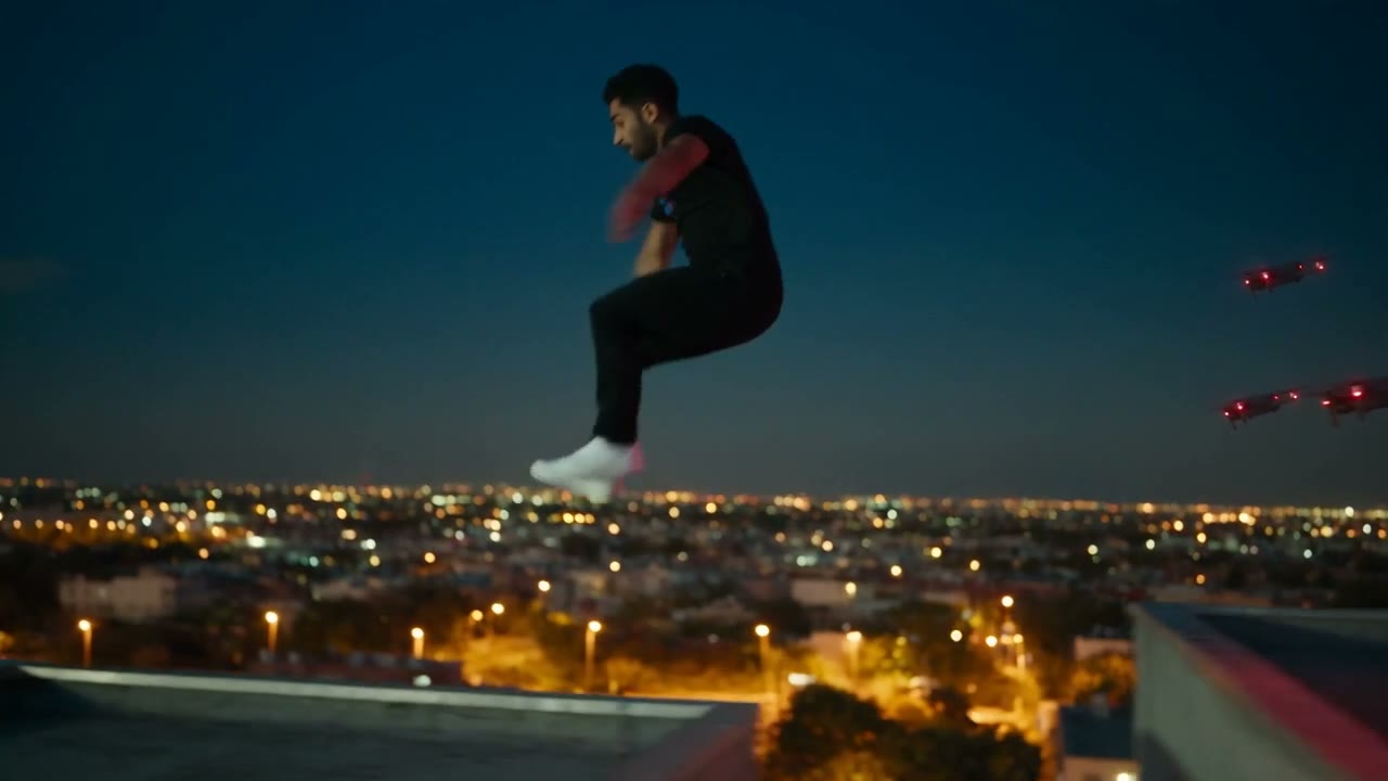 El personaje de Persistencia saltando entre azoteas de noche perseguido por drones